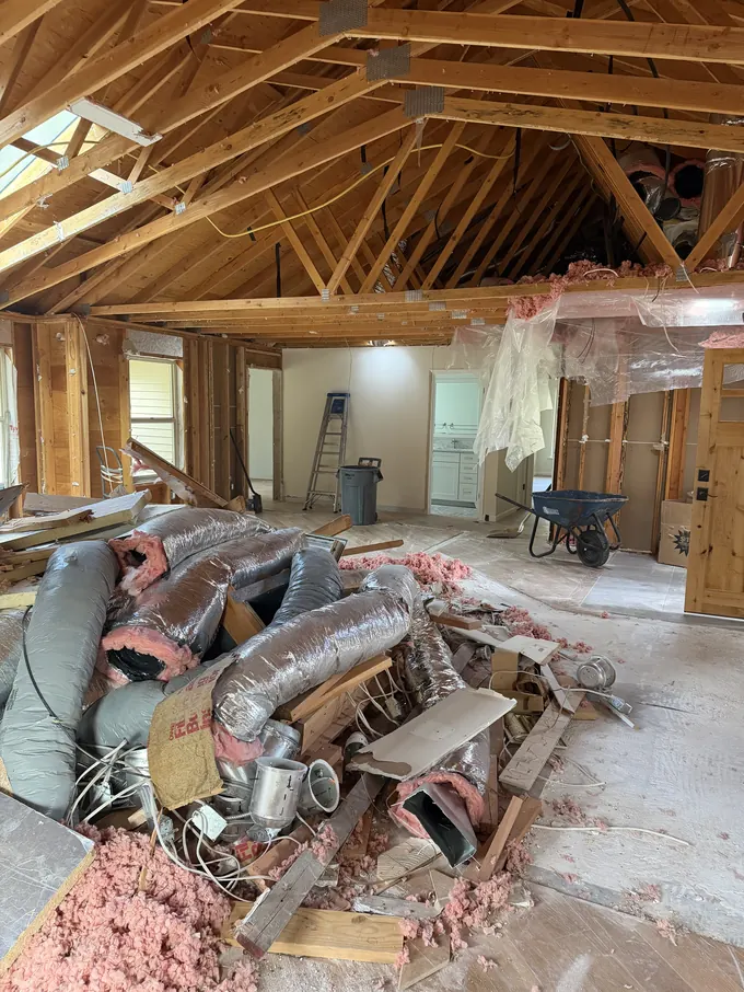 Interior gut-out with framing exposed and debris staged for haul-off