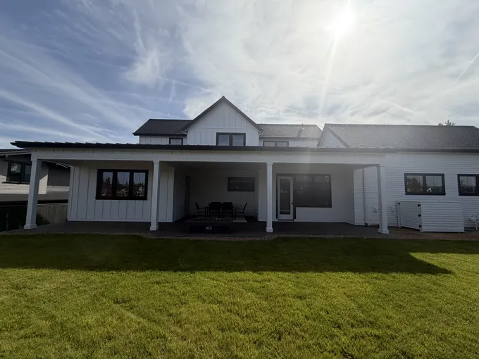 Completed white farmhouse-style home with covered porch